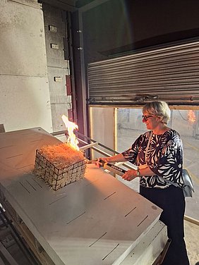 Staatssekretärin Silke Krebs entzündet einen Brandversuch für harte Bedachungen